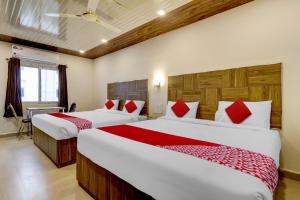 a hotel room with two beds and a desk at OYO Hotel Savitha's Grand in Vijayawāda