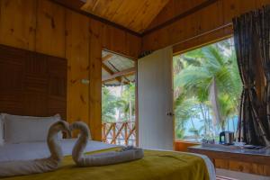 a bedroom with a bed with two swans on it at GRAND OCEANUS RESORT in Beadonābād