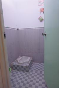 a bathroom with a toilet in a tiled floor at OYO 93731 Amas Syariah in Parepare