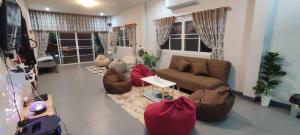 sala de estar con sofá, sillas y ventanas en กิติ์ชาวิว วิลล่า en Ban Nang Lae