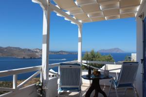 a porch with chairs and a view of the water at Studios Betty in Plaka Milou