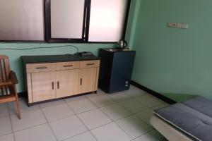 um quarto com uma cama e um armário de madeira em OYO 93764 Homestay Citra em Kendari