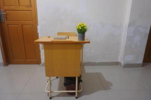 a desk with a computer and a plant on it at Hotel O Homestay Citra in Kendari +42 photos