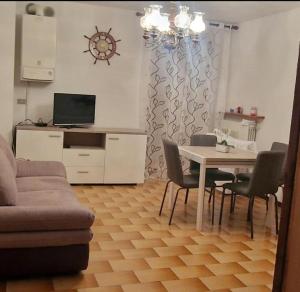 - un salon avec une table, des chaises et un canapé dans l'établissement Residenza Rovetta, à Rovetta