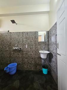uma casa de banho com lavatório e baldes azuis em Ranikheth Ecostay em Kalimpong