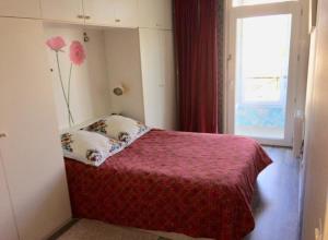 um quarto com uma cama com uma colcha vermelha e uma janela em Grand Appartement proche d’Orly et Paris em Ris-Orangis