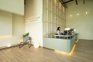 a woman standing at a counter in a office at Amber Cove Premier Suites Melaka in Melaka