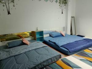 2 Betten nebeneinander in einem Zimmer in der Unterkunft พญาเกสท์เฮ้าส์ in Nakhon Phanom