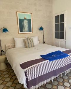 sypialnia z dużym białym łóżkiem z 2 niebieskimi lampami w obiekcie Nelli's B&B w mieście Cospicua