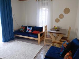 sala de estar con sofá azul y mesa en Amaryllis blue,8mins source to River Nile,secure, peaceful, central great location, en Jinja
