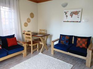 sala de estar con sofá y mesa en Amaryllis blue,8mins source to River Nile,secure, peaceful, central great location, en Jinja