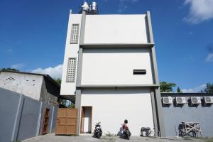 two motorcycles parked in front of a white building at OYO 93770 Pondom Danu 77 in Kendari