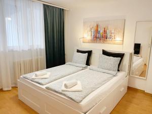 a white bed with two white towels on it at Cherry Apartment Arena in Belgrade