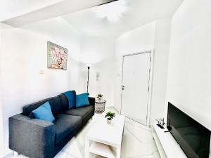 a living room with a blue couch and a tv at Nicolas 1 in Larnaca