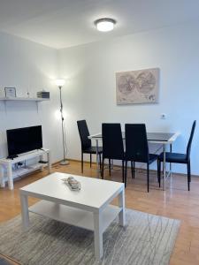 a living room with a table and chairs and a tv at Cherry Apartment Arena in Belgrade