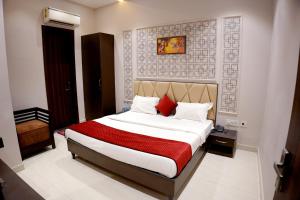 een slaapkamer met een bed met een rode deken bij Hotel Swastik 5 Minutes walking From Golden Temple in Amritsar