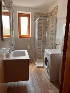 y baño con lavabo y lavadora. en Residenza Rovetta, en Rovetta