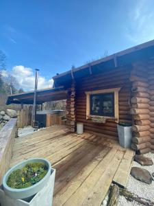 a cabin with a wooden deck with a blue roof at LA YOURTE DU RANDONNEUR in Rimbach-près-Masevaux