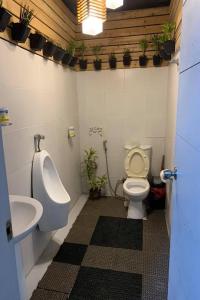 a bathroom with a toilet and a urinal and a sink at Surfer's Point Deck in San Juan
