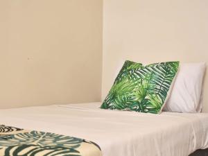 uma cama com almofadas verdes e brancas em Stay Inn Plus em Mexico