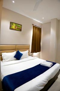 een slaapkamer met een groot bed met blauwe en witte kussens bij Hotel Swastik 5 Minutes walking From Golden Temple in Amritsar