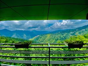 a view of mountains from a balcony with plants at Aachman Nature Valley Resort Shimla in Shimla