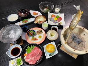 una mesa cubierta con platos de comida en una mesa en Yunominesou, en Hongū