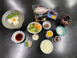 una mesa cubierta con tazones de comida y otros ingredientes en Yunominesou, en Hongū
