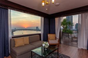 a living room with a couch and a large window at Ramada Plaza by Wyndham Bangkok Menam Riverside in Bangkok