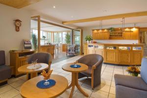 a kitchen and living room with two tables and chairs at Landgasthaus Hotel Maien in Rheinfelden