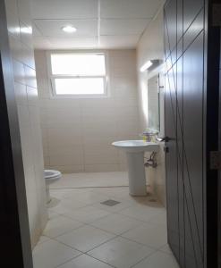 a bathroom with a sink and a toilet and a window at AL ALKEEM HEIGHTS in Ras al Khaimah