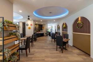 een restaurant met tafels en stoelen en een blauw plafond bij Everyday Hotel Kuta Central in Kuta