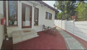 un patio d'une maison avec une table et des chaises dans l'établissement Bryanston Guest Cottage, à Johannesbourg