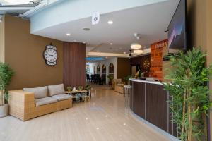 a lobby with a couch and a clock on the wall at Everyday Hotel Kuta Central in Kuta