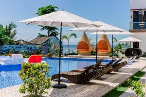 a swimming pool with lounge chairs and umbrellas next to a pool at Sonrisa Resort De Playa by Hiverooms in San Remigio
