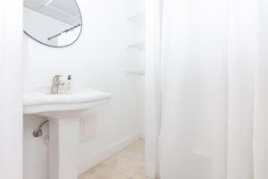 a white bathroom with a sink and a mirror at 1-BDRM Apartment with Balcony - Heart of Downtown and Wynwood in Miami