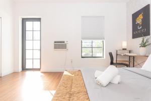 a white living room with a bed and a table at 1-BDRM Apartment with Balcony - Heart of Downtown and Wynwood in Miami