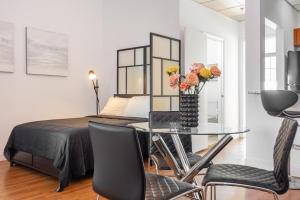 Un dormitorio con una cama y una mesa con flores. en 1-BDRM Apartment with Balcony - Heart of Downtown and Wynwood, en Miami