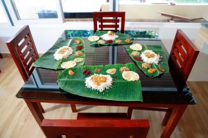 uma mesa com pratos verdes de comida em Nisarga Ayurveda em Kizhake Chālakudi