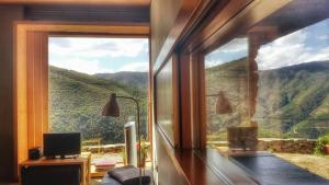 a room with a large window with a mountain view at InXisto Lodges in Piódão