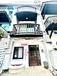 a white building with a door and a balcony at Nanwan254 Homestay in Nanwan