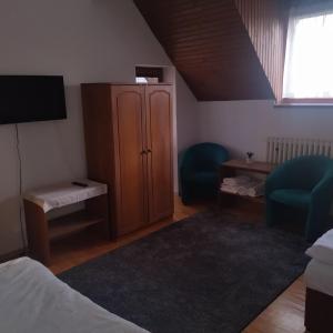 ein Schlafzimmer mit einem Schrank und zwei blauen Stühlen in der Unterkunft Penzion Helena in Stará Lesná