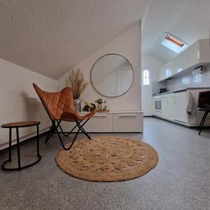 a living room with a chair and a round mirror at peaceful tiny house near forest in Rorschacherberg