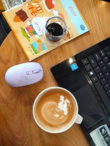 eine Tasse Kaffee neben einem Laptop in der Unterkunft Studio Healing Sayana Apartment in Tambun-lobangbuaja