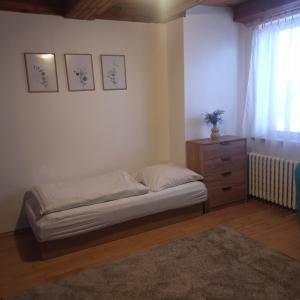 a bedroom with a bed and a dresser and a window at Penzion Helena in Stará Lesná