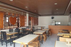 um restaurante com mesas e cadeiras e um coração na parede em OYO 93709 Rose Inn 2 em Medan