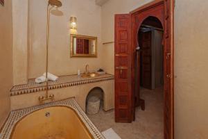 a bathroom with a tub and a sink at Riad Amalia in Marrakech