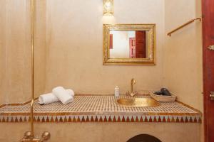 a bathroom with a sink and a mirror at Riad Amalia in Marrakech