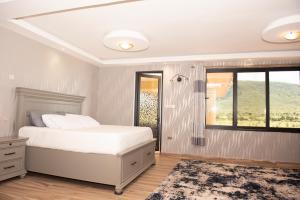 ein Schlafzimmer mit einem weißen Bett und einem Fenster in der Unterkunft Mara Meguarra Sanctuary in Ololaimutiek
