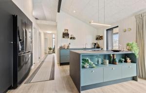 a large kitchen with blue cabinets and a sink at 4 Bedroom Gorgeous Home In Glesborg in Glesborg